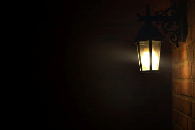 A porch light hung on a brick wall - red porch light